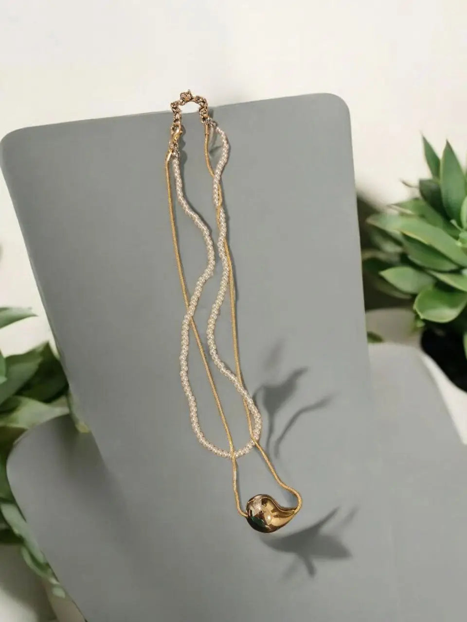 Elegant gold heart pendant necklace with pearl beaded layering, styled under natural light. Perfect for minimal and sophisticated jewellery lovers.
