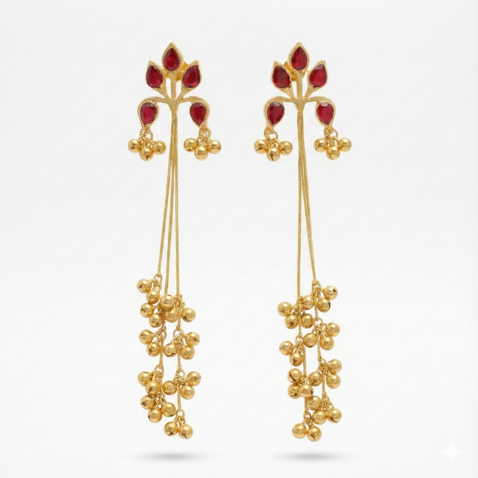 Gold earrings with red gemstones on a white background