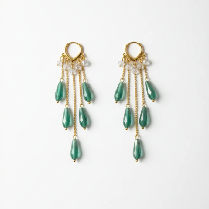 Pair of gold earrings with green teardrop-shaped beads on a white background