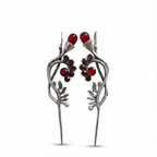 Silver hairpins with red gemstones on a white background