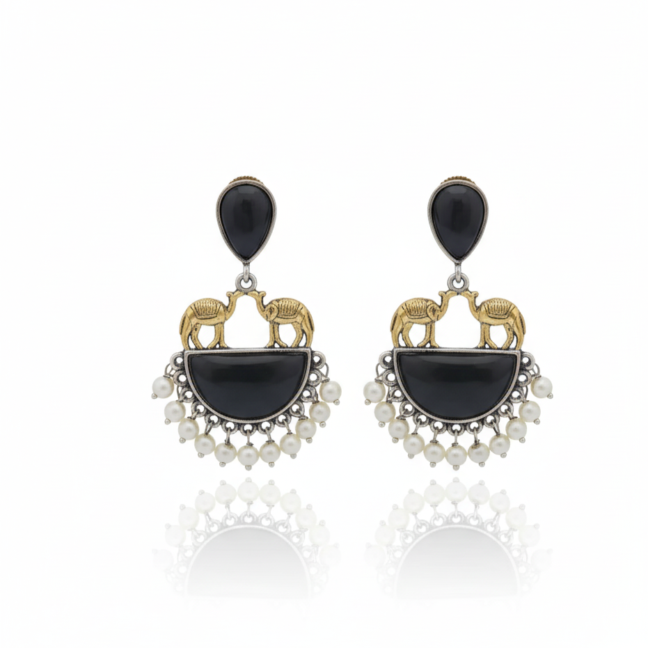 Pair of earrings with black stones and gold accents on a white background