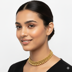 Woman wearing a gold necklace against a plain background