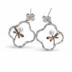 Pair of floral earrings with pearl accents on a white background