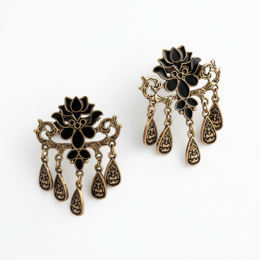Pair of ornate earrings with black and gold designs on a white background