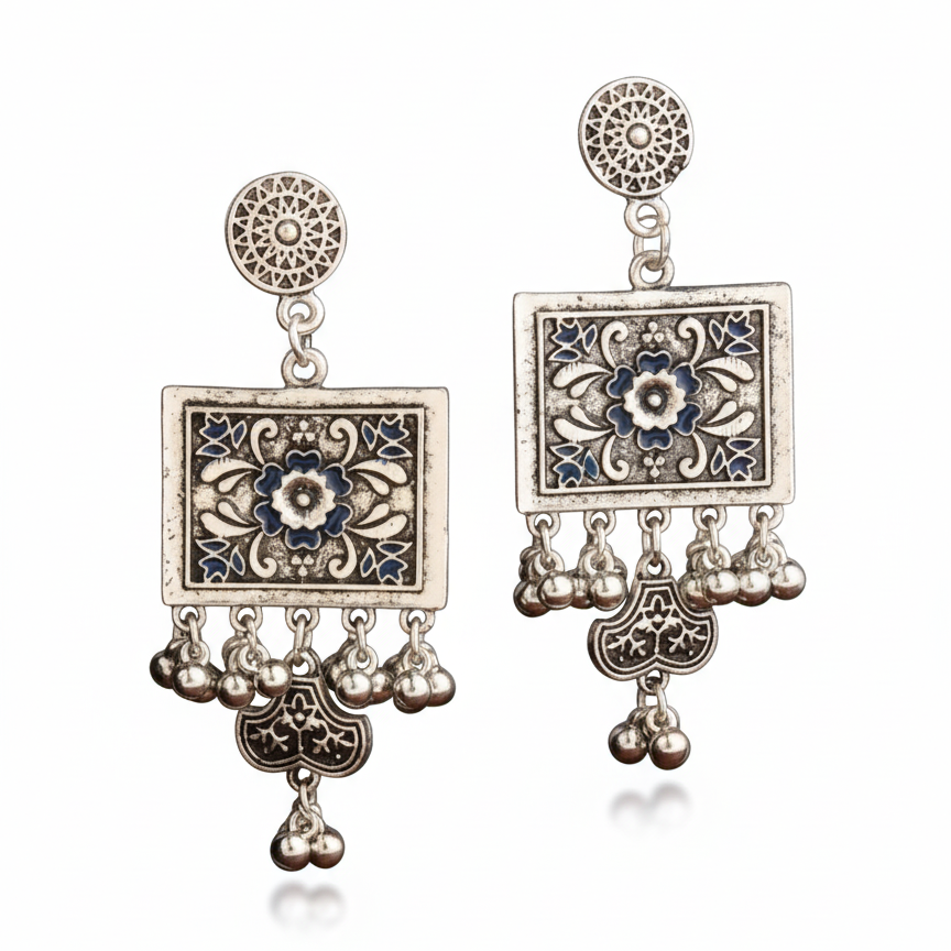 Pair of ornate earrings with floral designs and dangling beads on a white background