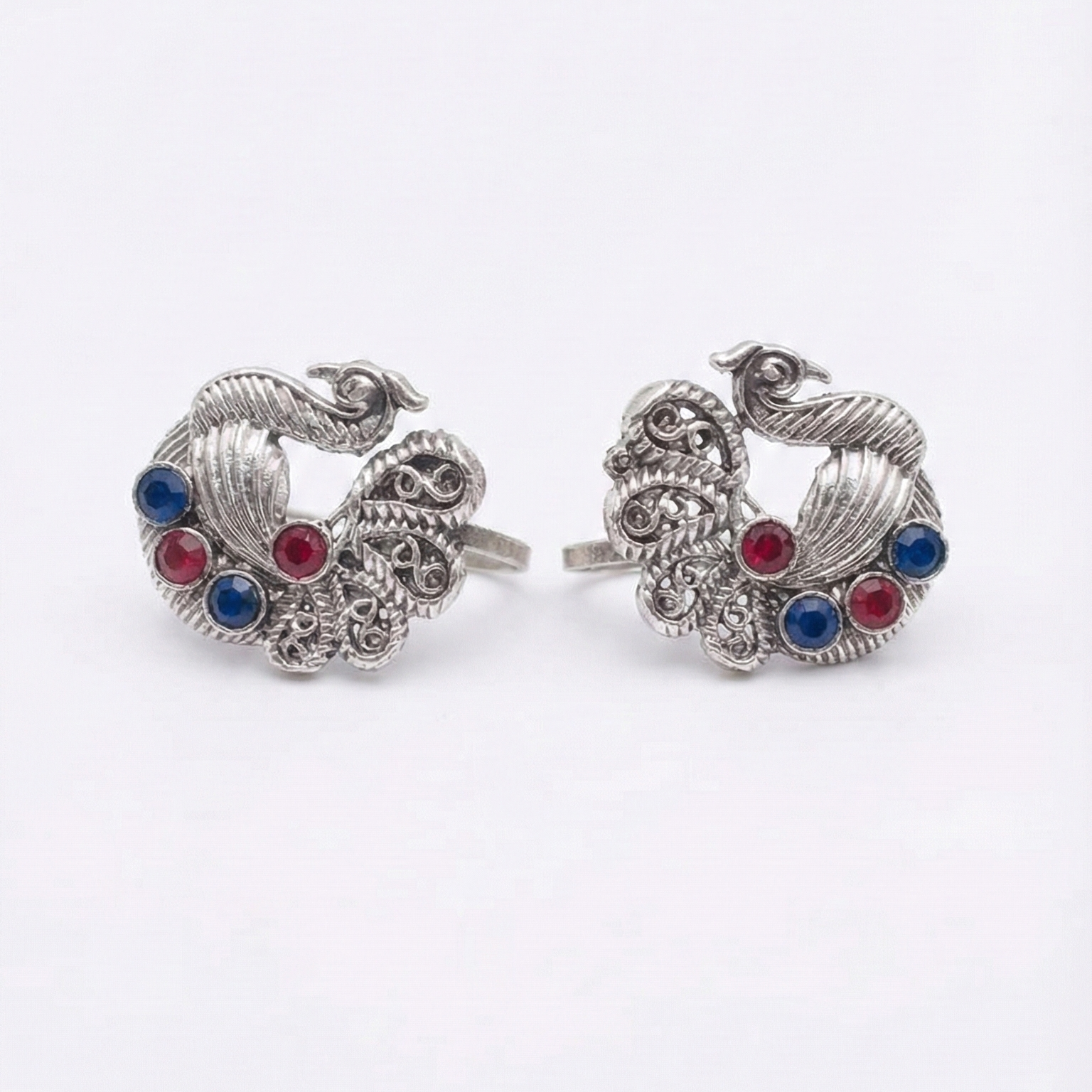 Pair of silver earrings with colorful gemstones on a white background