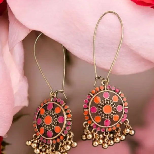 Boho antique gold dangler earrings with intricate orange and pink enamel detailing, finished with golden ghungroo drops, perfect for ethnic and fusion wear.
