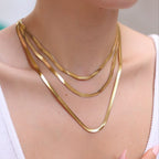 Gold necklace on a person wearing a white top